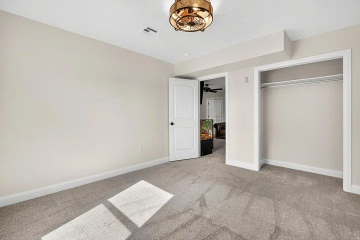 Neutral-toned wall finishes with a recessed closet featuring a hanging rod