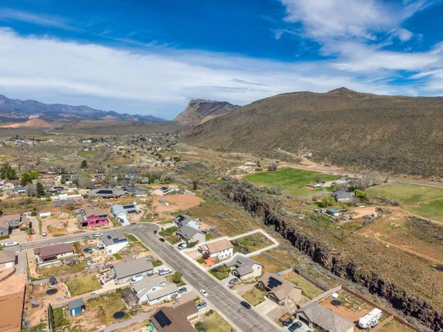 Expansive land parcel outlined in white, featuring natural terrain and distant mountainous backdrops
