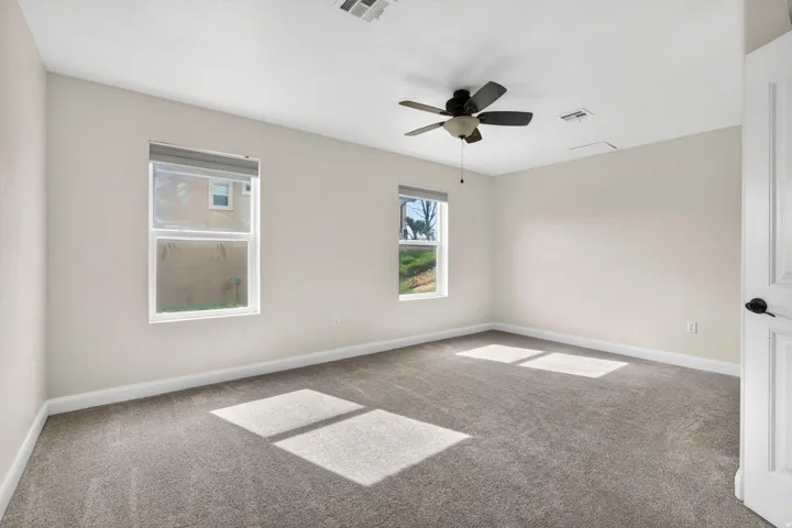 Spacious room featuring neutral carpeting and light-toned walls