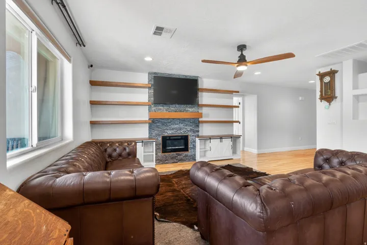 Living area featuring a stone accent wall with a built-in fireplace and a wall-mounted display