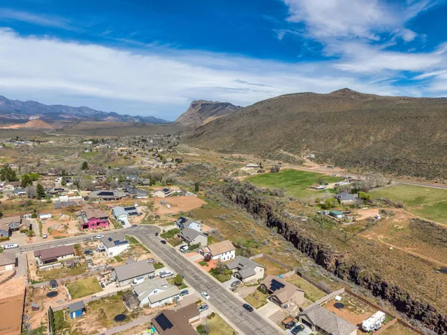 Expansive aerial perspective showcasing a residential neighborhood nestled within a mountainous valley