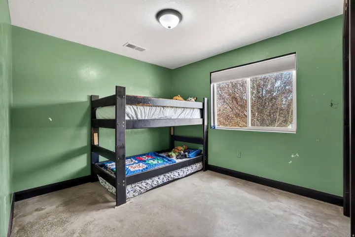 Room featuring a single window, a ceiling-mounted light fixture, and textured walls