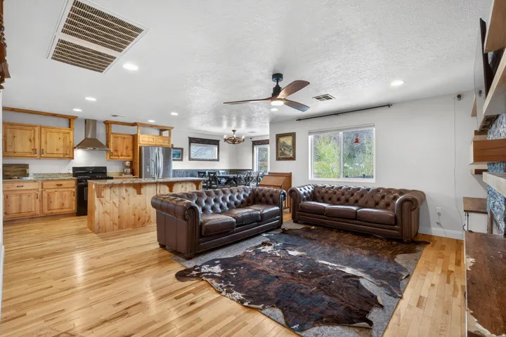 Open-concept living area featuring light wood-finish flooring, recessed lighting, and a ceiling fan