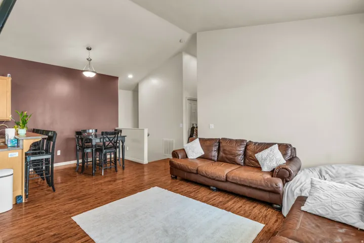 Spacious open-concept living area featuring wood-finish flooring and high vaulted ceilings