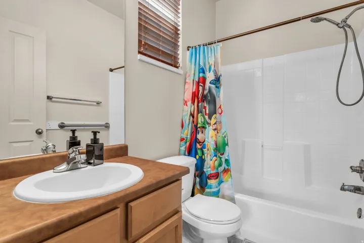 Bathroom featuring a single vanity with an integrated sink, wood-finish cabinetry, and a full-width mirror
