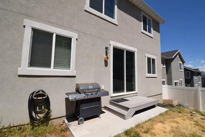 Rear exterior with a concrete patio, composite steps, and a sliding glass door
