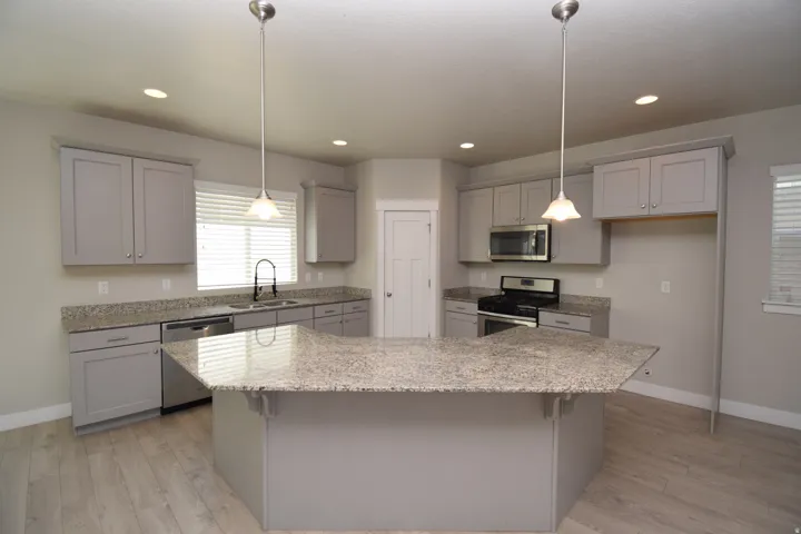 Kitchen featuring a central island, light gray cabinetry, and light-toned countertops