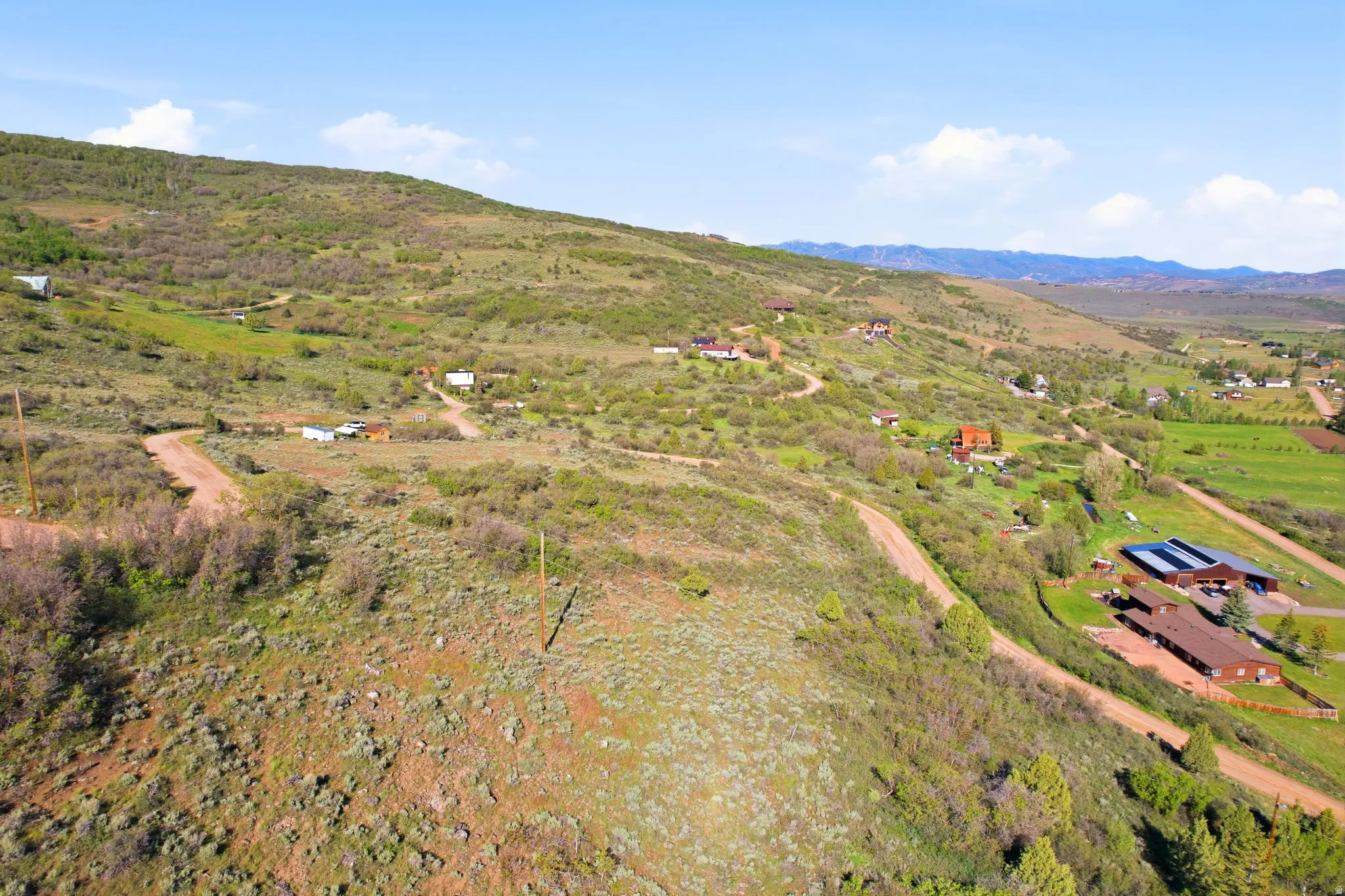 Expansive hillside acreage featuring natural vegetation and visible dirt roads