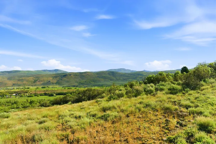 Expansive natural landscape with rolling hills and distant mountains