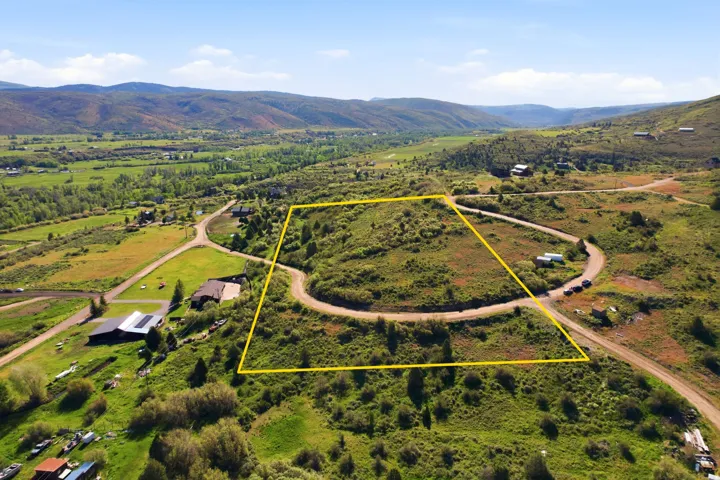 Expansive undeveloped land parcel with natural vegetation and surrounding mountainous terrain
