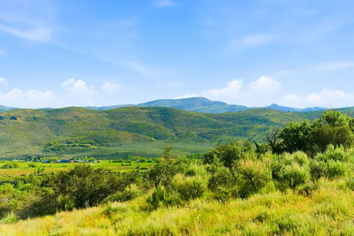 Expansive land parcel featuring rolling hills and lush green vegetation