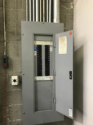 Electrical service panel featuring multiple circuits and exposed conduit