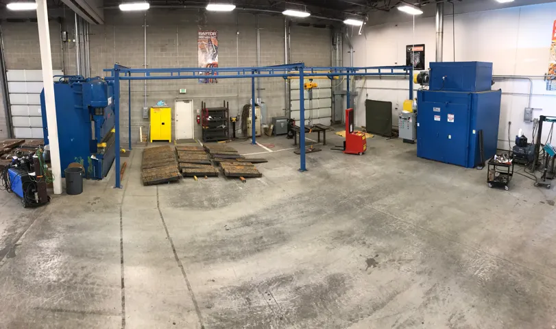 Spacious industrial interior featuring concrete block walls and a high ceiling with overhead lighting
