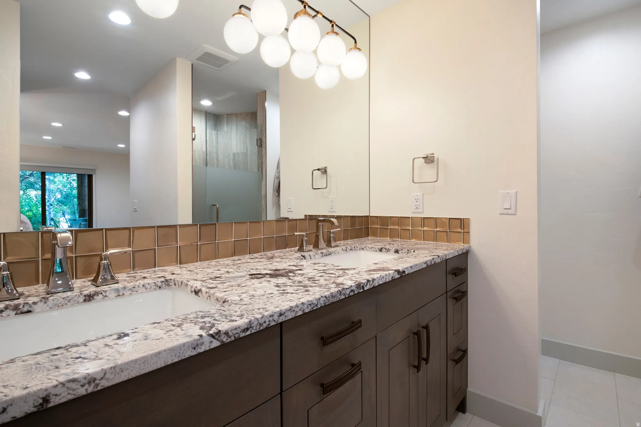 Double vanity with granite countertop, undermount sinks, and brushed nickel faucets
