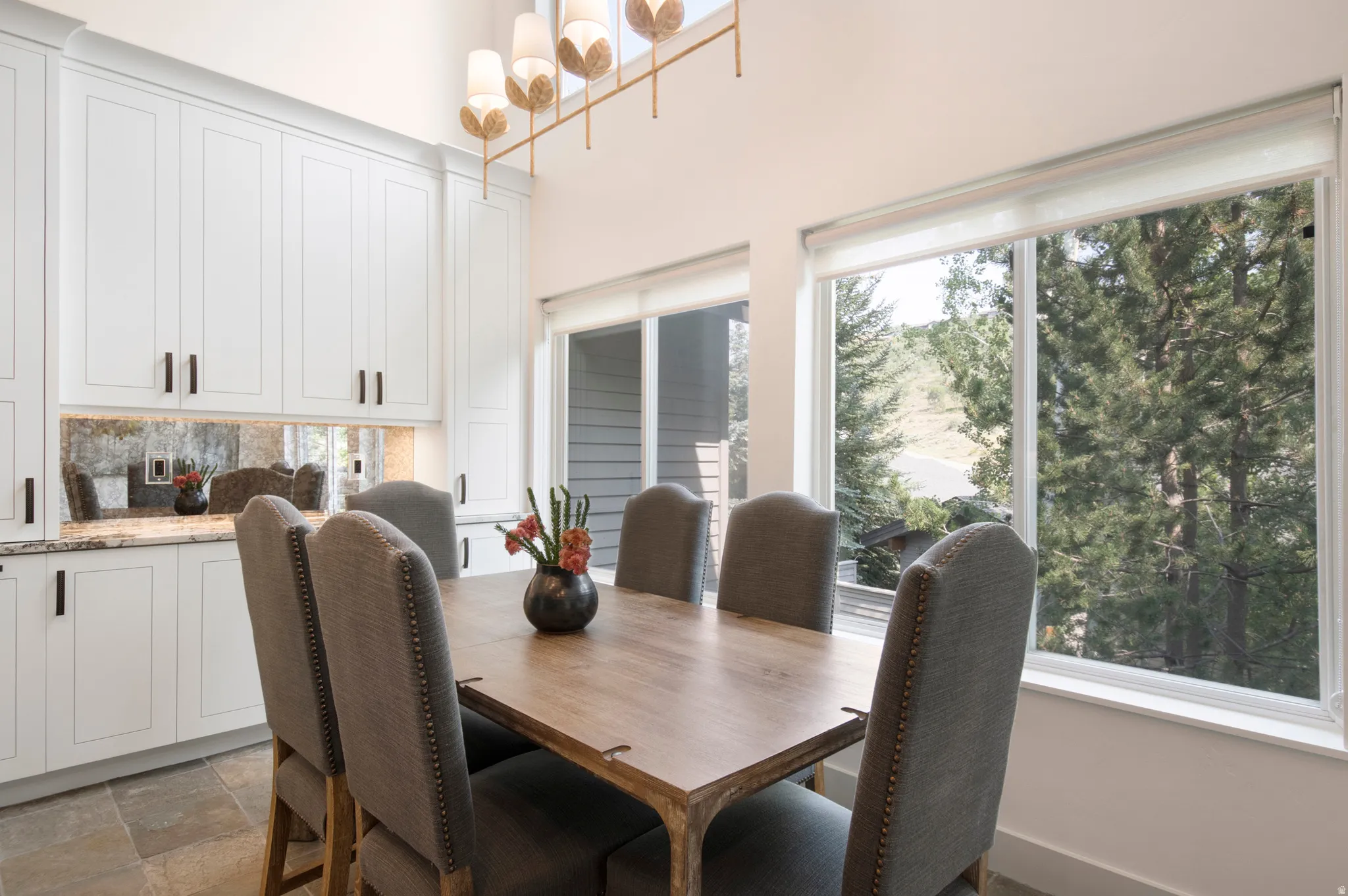 Dining area featuring floor-to-ceiling white cabinetry with dark hardware and under-cabinet lighting