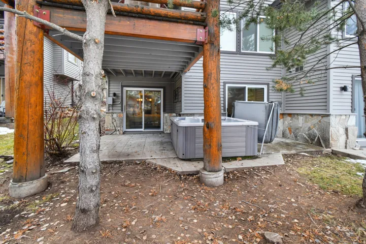 Private patio featuring a hot tub, concrete paving, and a sliding glass door entry