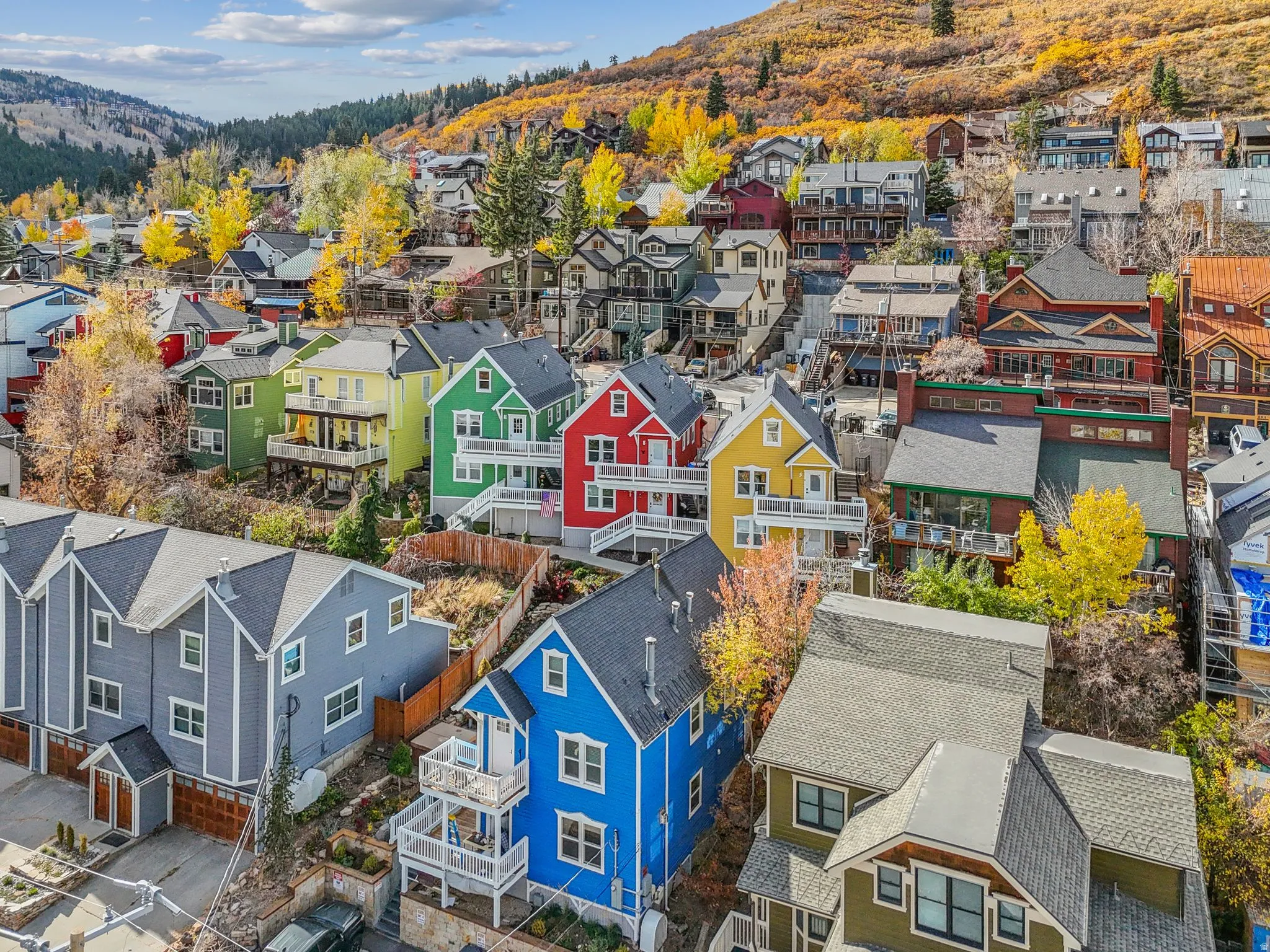 Hillside residential architecture featuring a combination of colorful facades, multi-level balconies, and varied rooflines