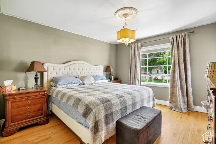 Bright room featuring hardwood flooring, a large window with exterior views, and neutral wall tones