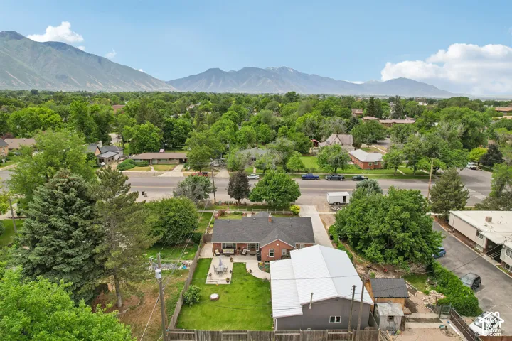 Aerial perspective showcasing a residential property with a red brick facade and a dark shingle roof