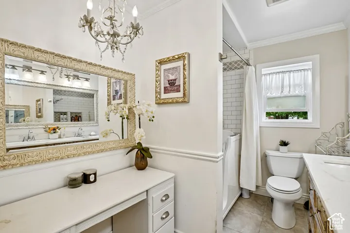 Bathroom featuring a decorative vanity area with a large framed mirror, chandelier, and built-in storage