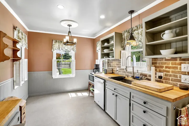 Kitchen featuring wood-finish countertops, brick-style backsplash, white beadboard wainscoting, and a ceiling-mounted light fixture with a decorative medallion