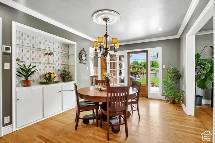 Dining area with light wood-finish flooring and a central chandelier