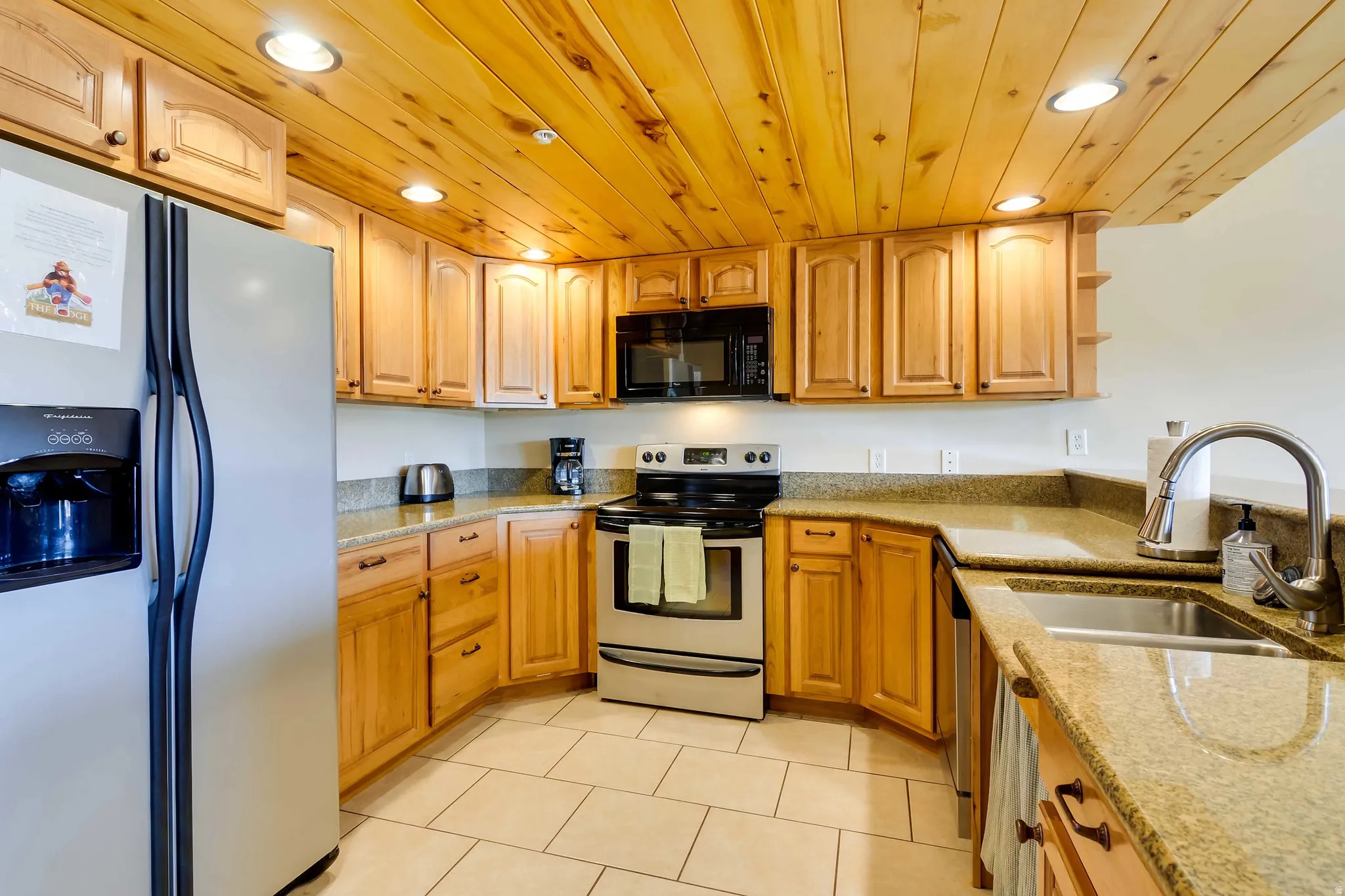 Kitchen featuring recessed lighting, natural wood paneling ceiling, wood cabinetry, stone countertops, and tile flooring