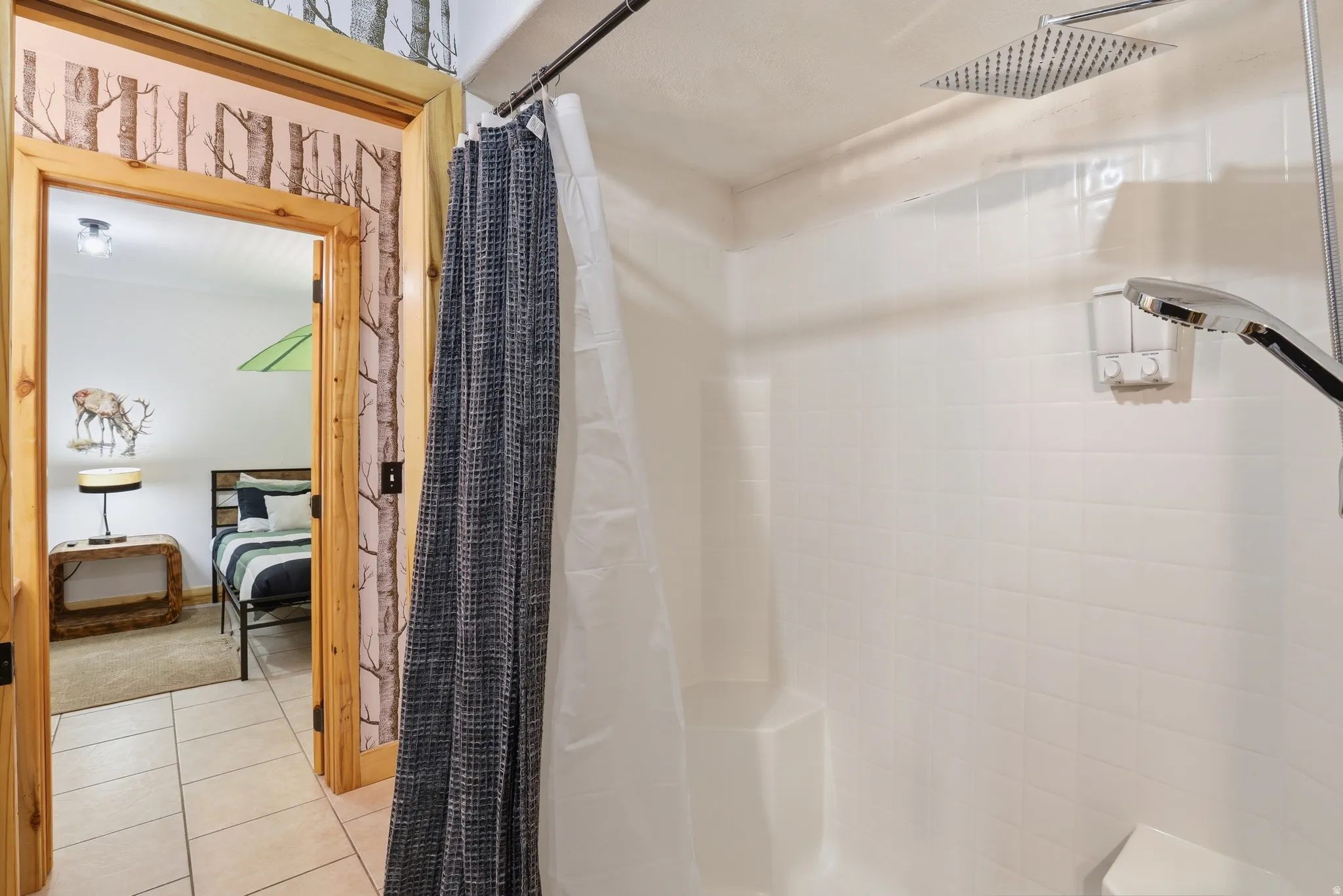 Shower featuring a rainfall showerhead, a handheld shower fixture, and a built-in corner bench