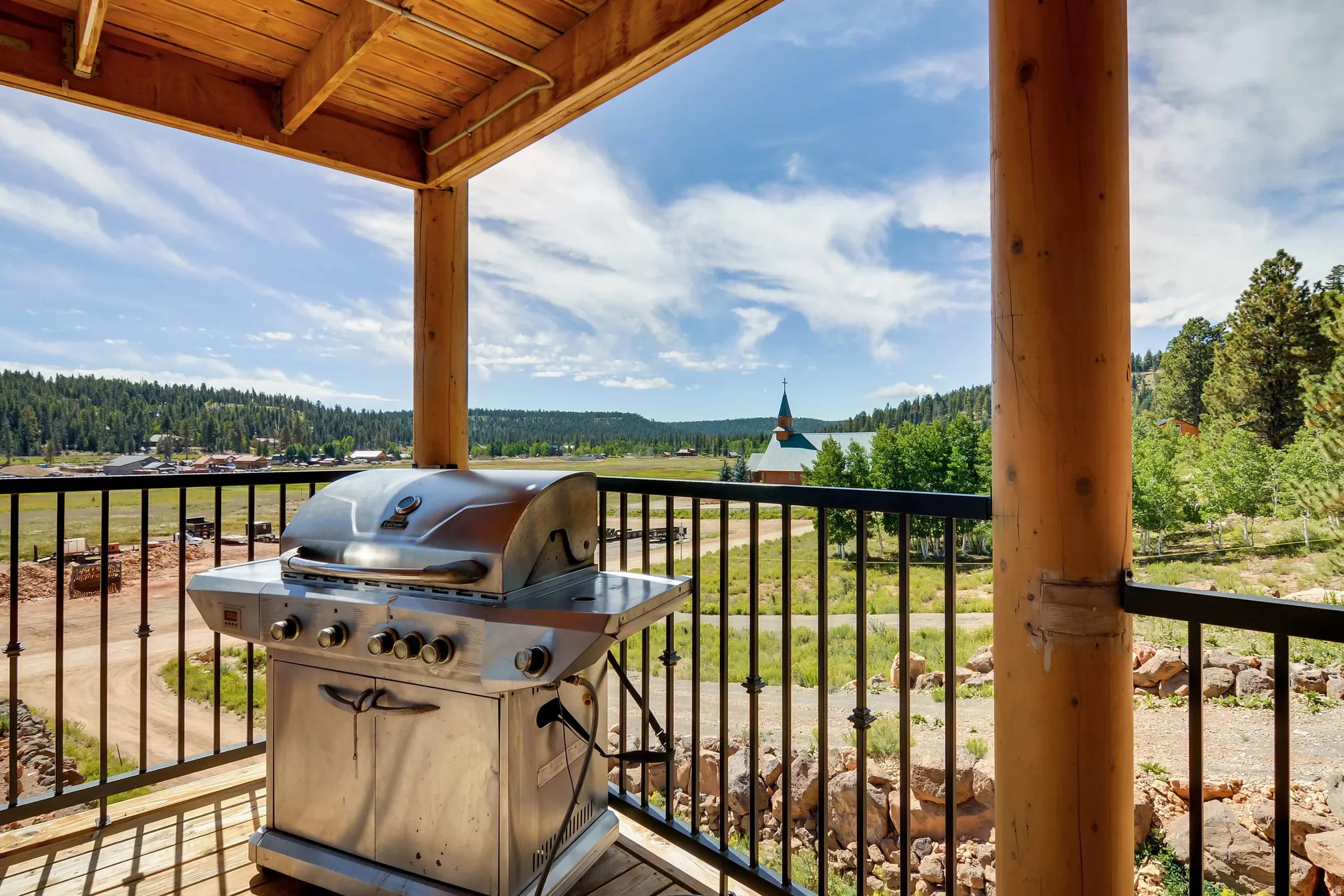 Covered outdoor deck with exposed wood ceiling beams and natural wood posts