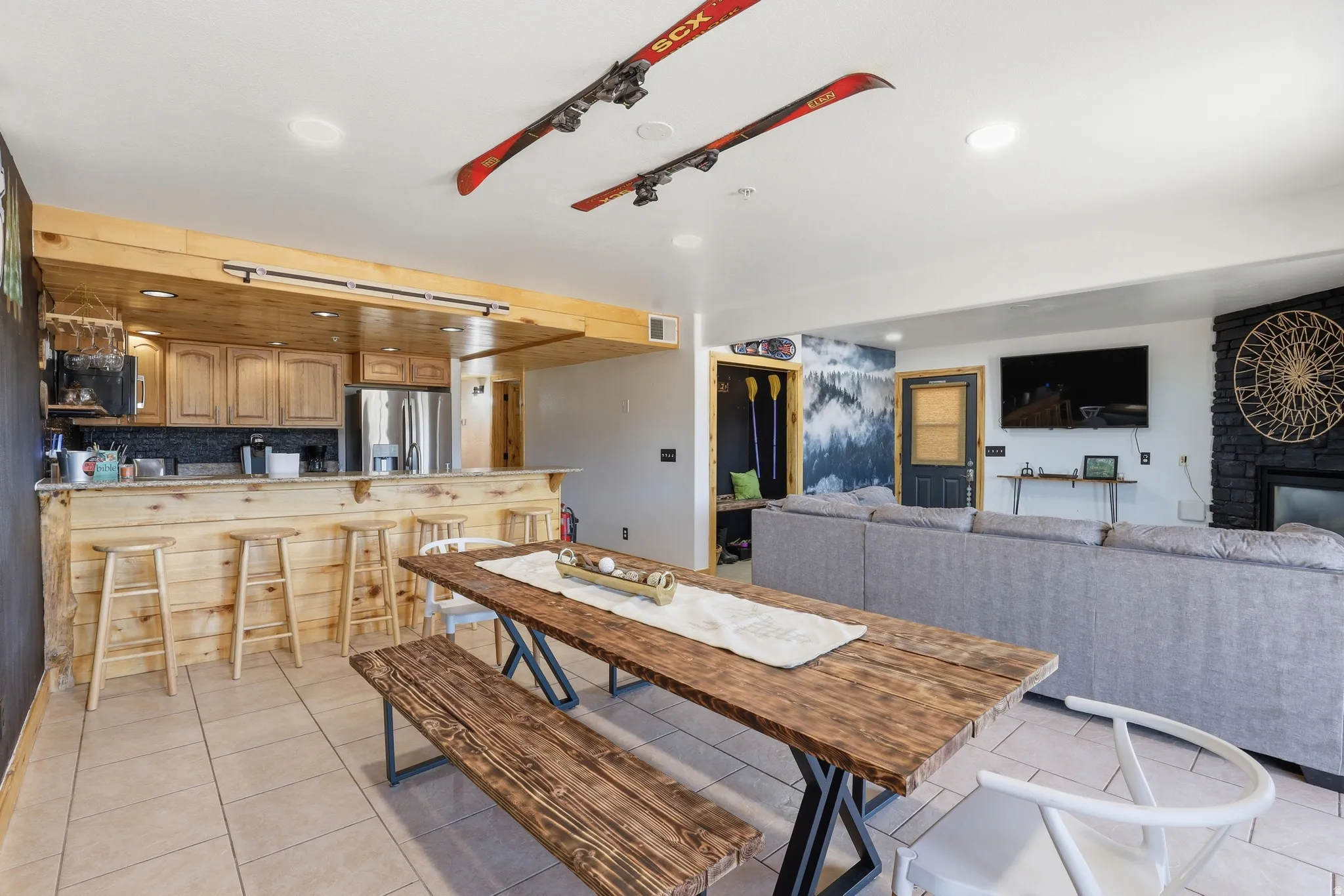 Open-concept living space featuring a wood-finish bar with light-toned cabinetry and stainless steel appliances