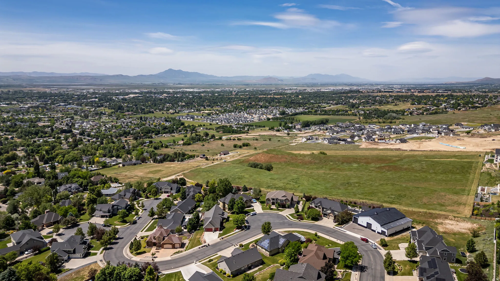 Expansive aerial perspective showcasing a residential neighborhood with established homes and developing areas