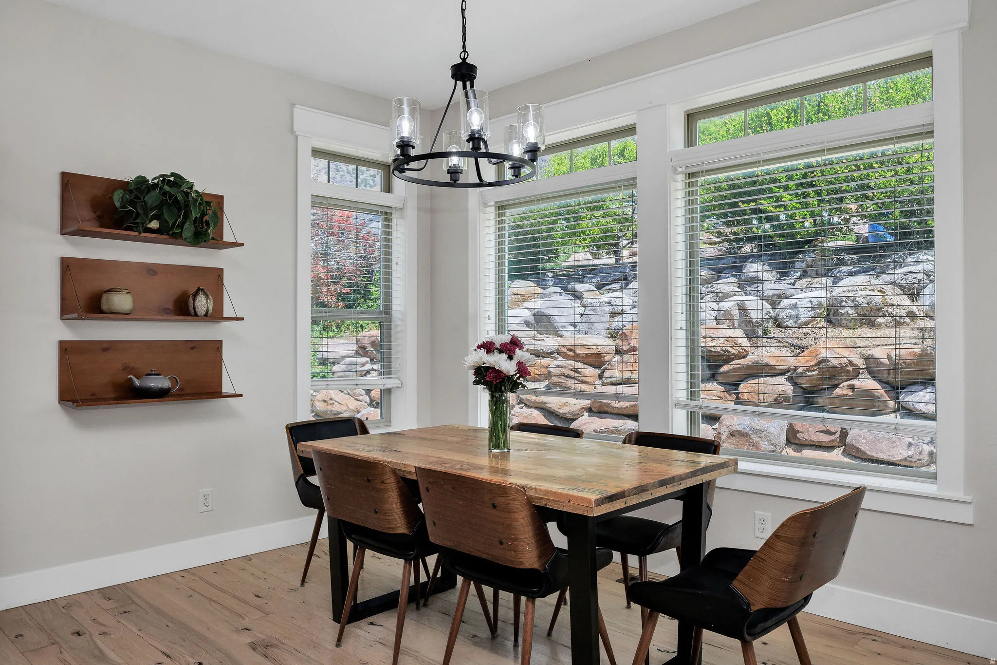 Dining area featuring wood-finish flooring and a contemporary chandelier