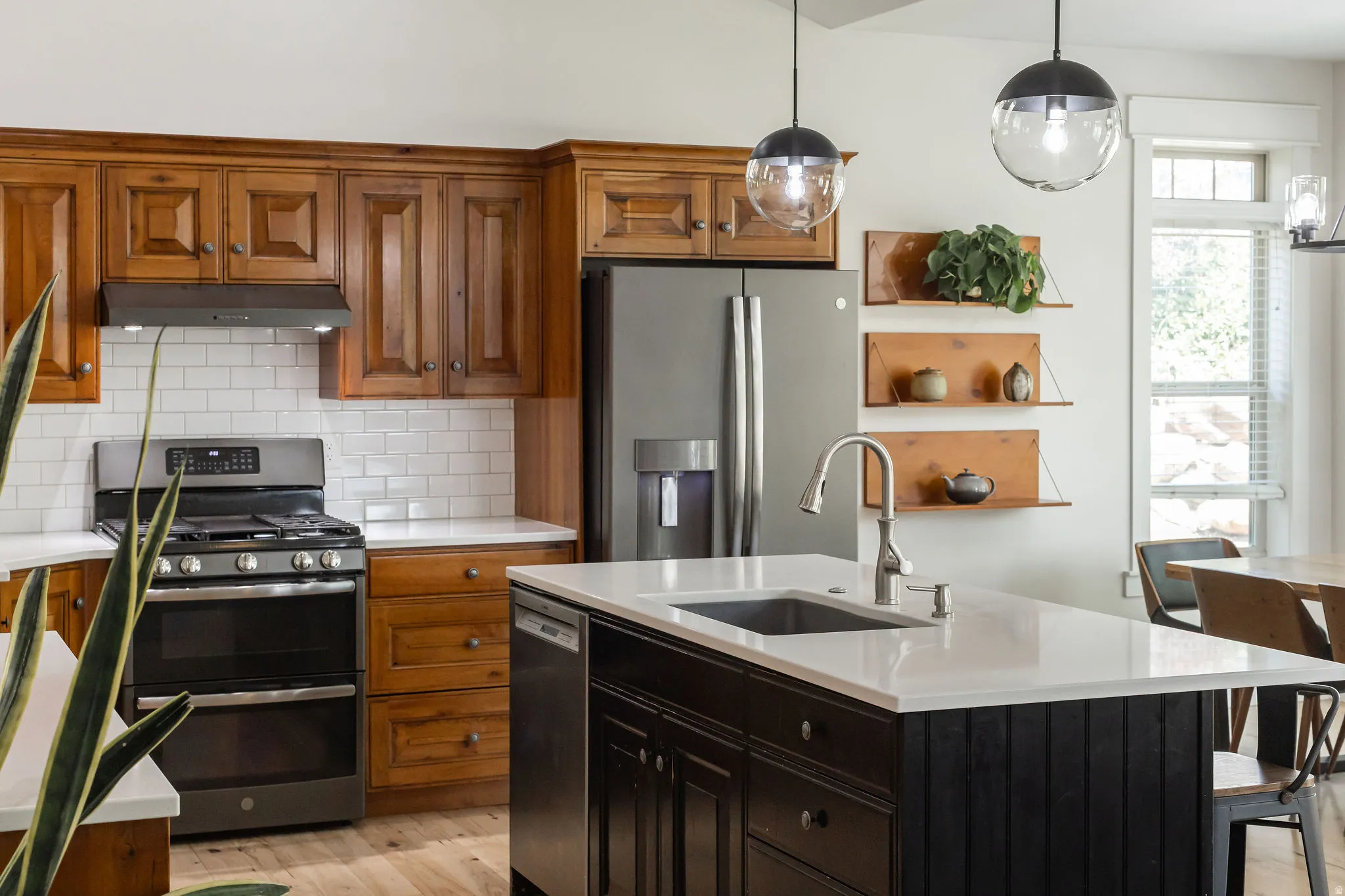 Kitchen featuring wood cabinetry, white subway tile backsplash, and stainless steel appliances