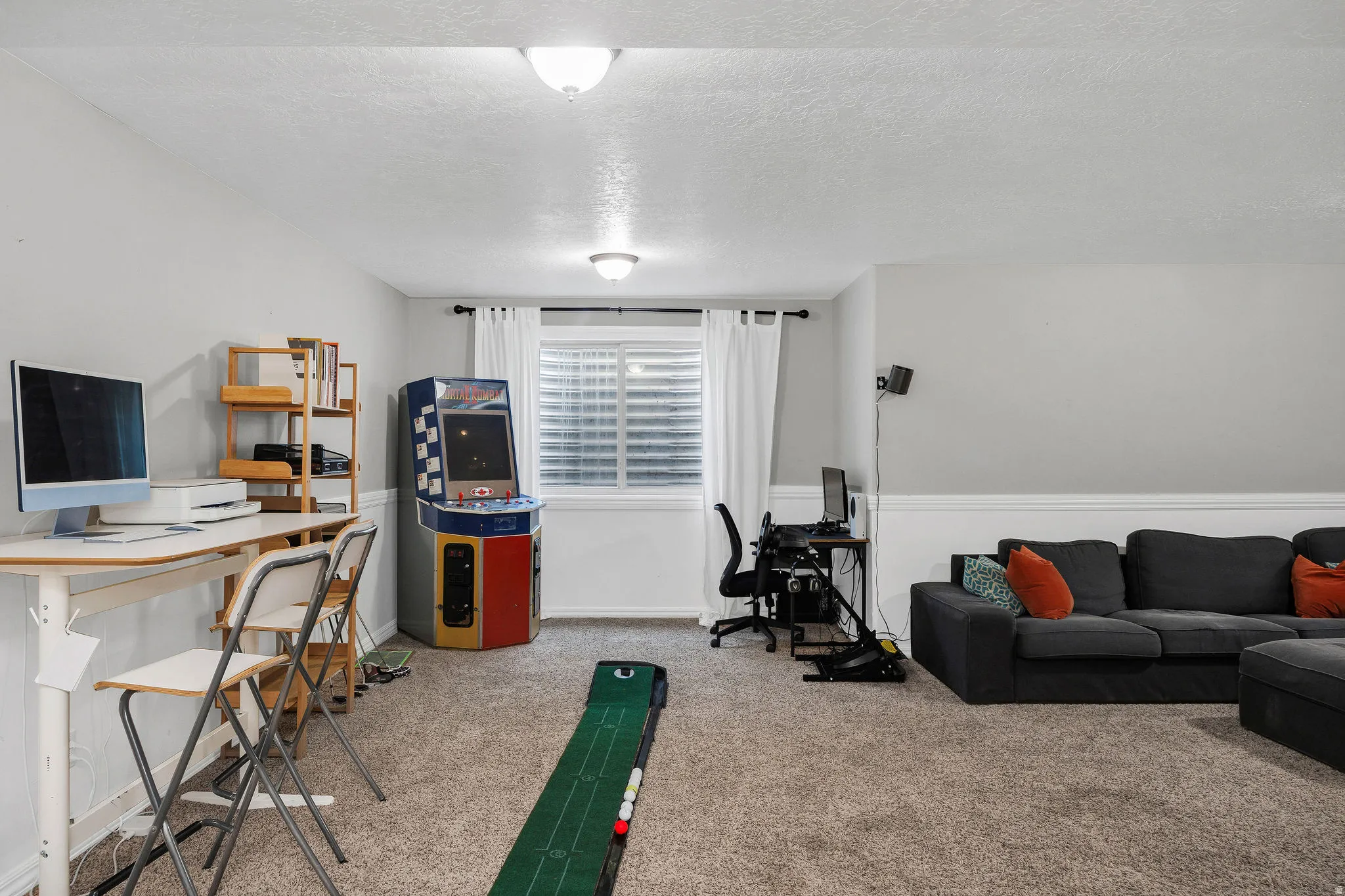 Carpeted open-concept room with light gray walls and white trim