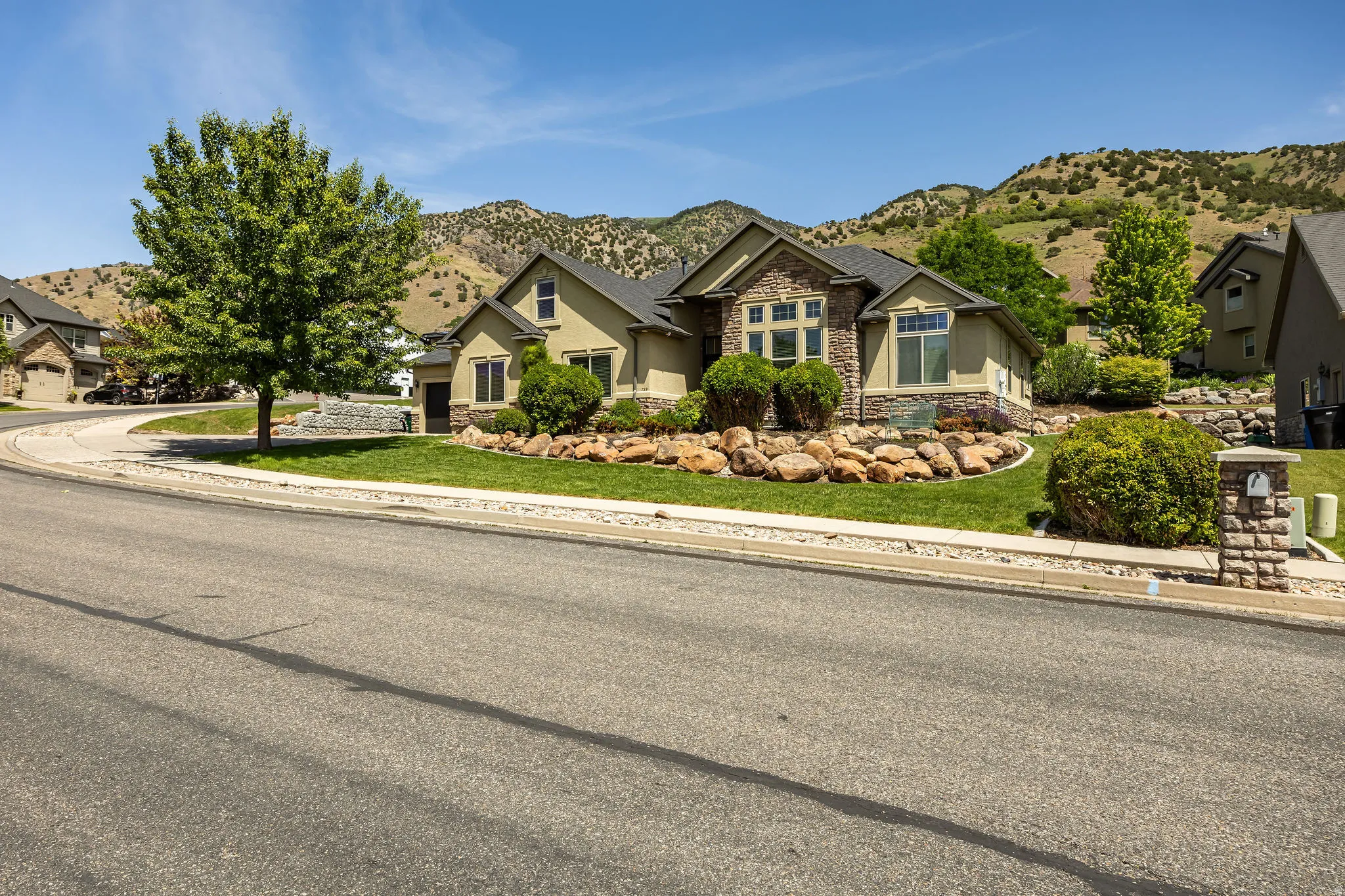 Stone and stucco exterior with multiple gables and dark roofing