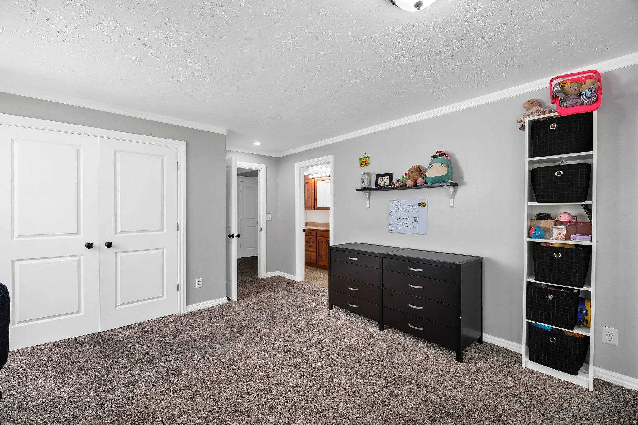 Room featuring gray wall paint, white baseboards, and white crown molding