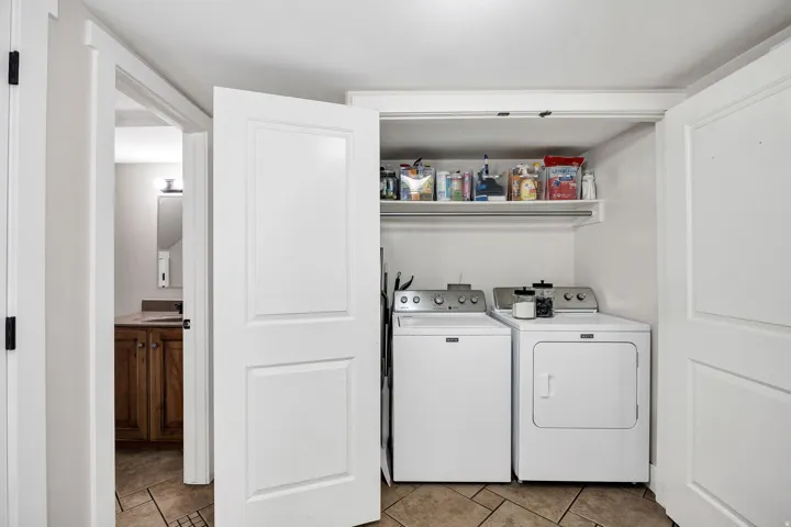 Dedicated laundry closet featuring a built-in shelf and hanging rod