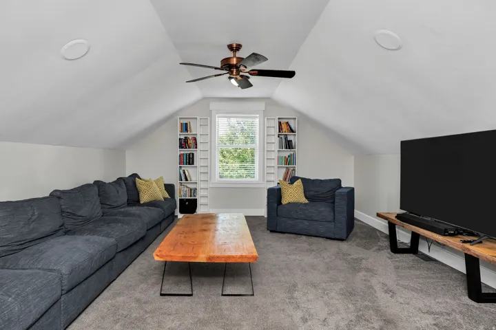 Spacious bonus room featuring sloped ceilings, recessed lighting, and a prominent ceiling fan