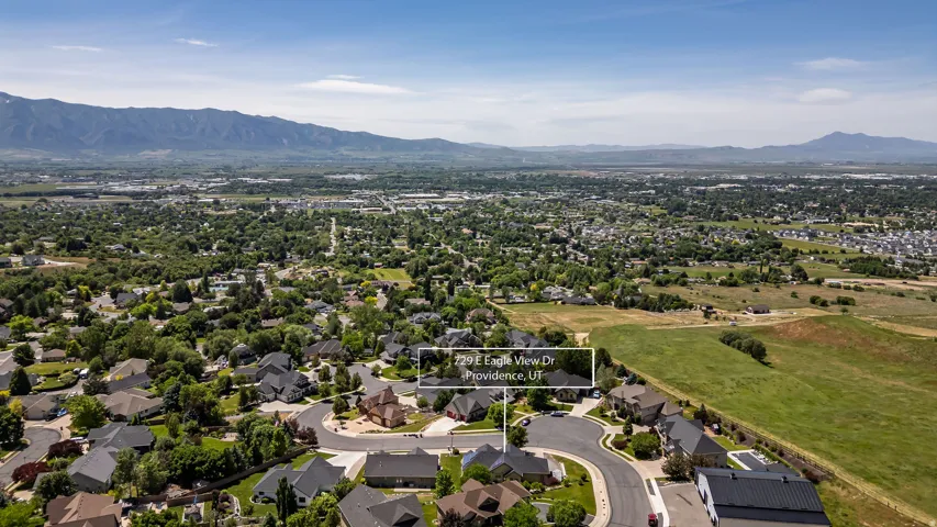 Aerial perspective showcasing a residential neighborhood with surrounding mountains and expansive green spaces