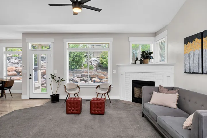 Living area with a corner fireplace featuring a white mantel and subway tile surround
