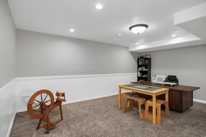 Carpeted room with recessed lighting and a flush-mount fixture, featuring gray walls with white wainscoting and trim