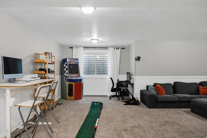 Carpeted open-concept room with light gray walls and white trim