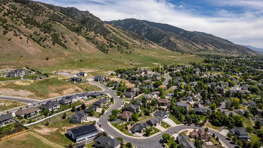 Aerial perspective showcasing a residential community nestled against a mountainous backdrop