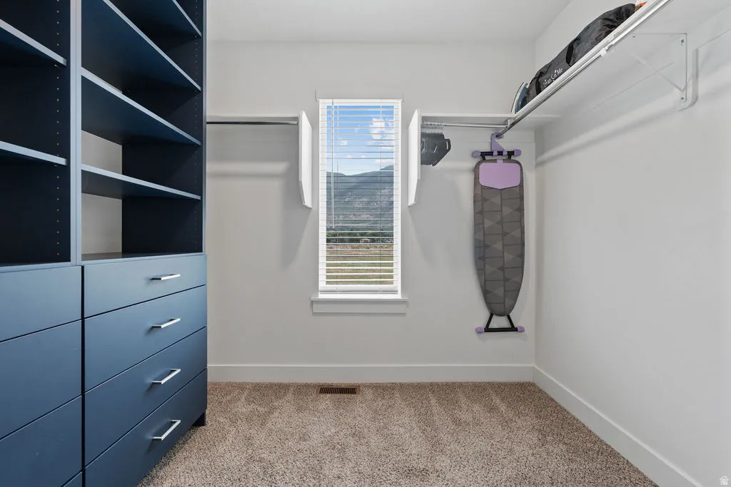 Custom closet system featuring dark blue built-in shelving and drawers with brushed nickel hardware