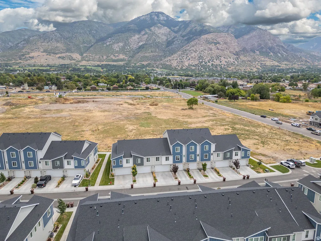 Newly constructed townhomes featuring multi-tone siding, dark shingle roofs, and individual garage entrances