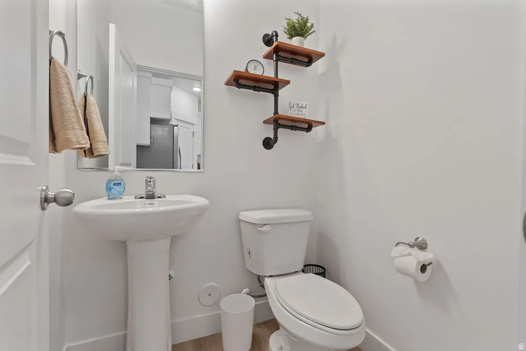 Powder room with a white pedestal sink, chrome faucet, and rectangular wall mirror