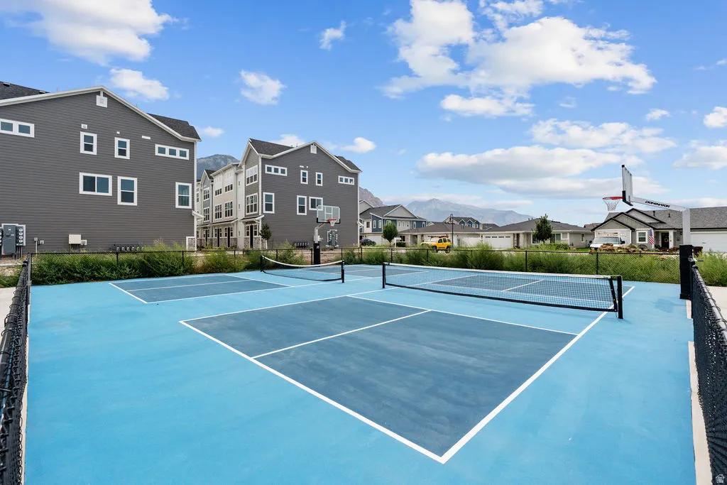 Blue-surfaced sports court with white line markings and multiple nets