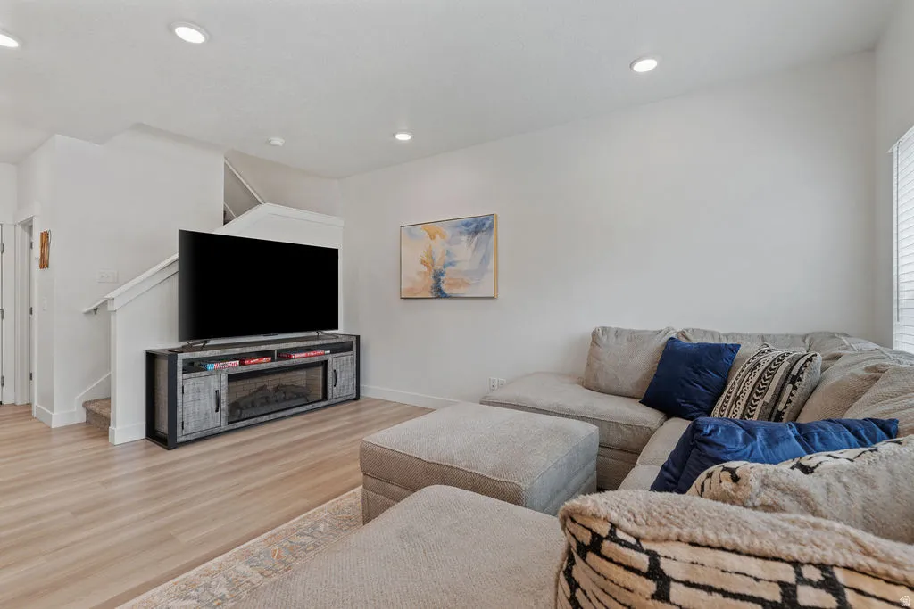 Bright living space featuring recessed lighting, light wood-finish flooring, and white walls