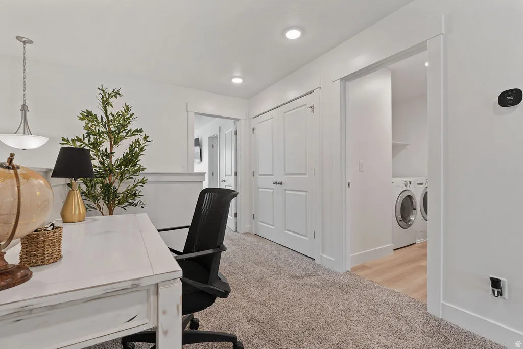 Carpeted hallway featuring bright white walls, recessed lighting, and a built-in closet with double doors