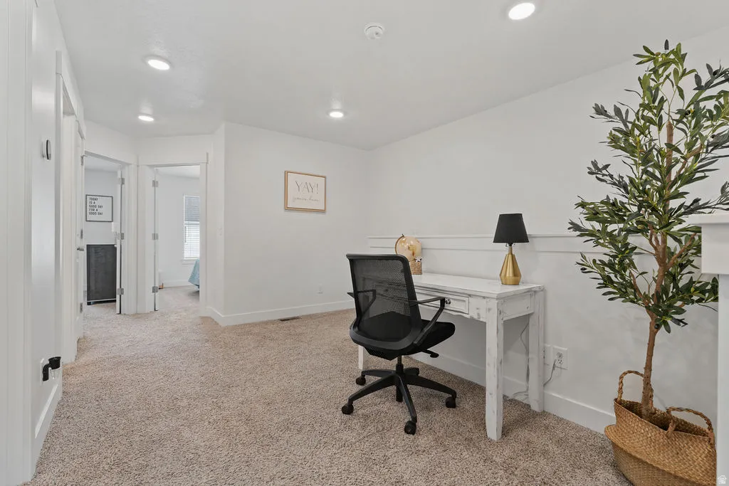 Carpeted room featuring white walls with wainscoting and recessed lighting